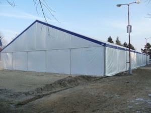 Jezdecká hala – boční pohled na bílou plachtovou halu s modrým lemem