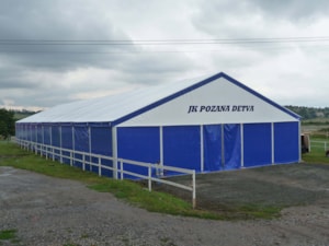 Jezdecká hala s modrým opláštěním a bílým štítem – čelní pohled