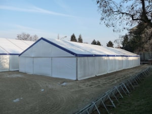 Jezdecká hala – exteriér, boční pohled u ohrady (bílé opláštění, modrý lem)