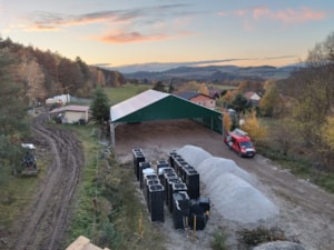 Pohled z výšky na jezdecký areál – hala/přístřešek se zelenou střechou