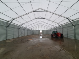 Interiér haly s plechovými boky – pracovní technika, mokrá podlaha po dešti