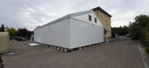 Hala s pevnými boky na montážní ploše – dokončování opláštění u budovy