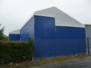 Hala s pevnými boky u oplocení – modré opláštění, sedlový štít