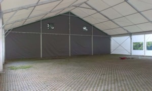 Fabric tent hall interior with a rigid end wall – paved floor and covered space