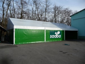 Lange Planen-Zelthalle mit grüner Verkleidung – seitliche Werbefläche an der Halle