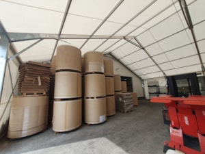 Interiér přístavby z plachtové haly – skladování materiálu v rolích pod plachtovou střechou