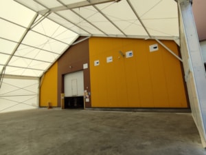 Interiér přístavby z plachtové haly – krytý prostor u stěny budovy, velká volná šířka