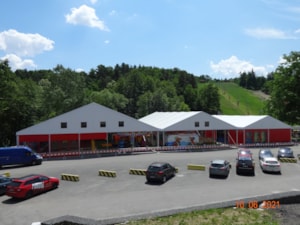 Plachtové športové haly s červeným opláštením v areáli voľnočasových aktivít