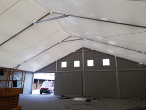 Insulated tent hall with a front wall, entrance opening and light panels
