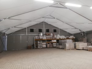 Insulated tent storage hall with lighting and stored materials