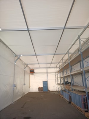 Insulated fabric hall with storage racks and temperature-controlled operation