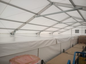 Insulated tent hall with a detail of the inner roof liner and structure