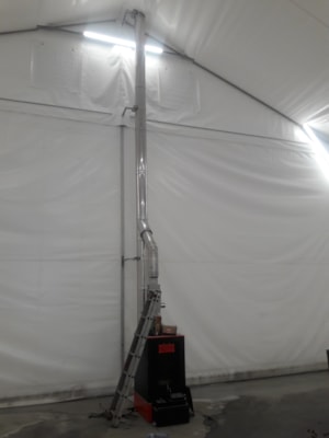 Insulated fabric hall with a heater and flue exhaust for temperature-controlled use