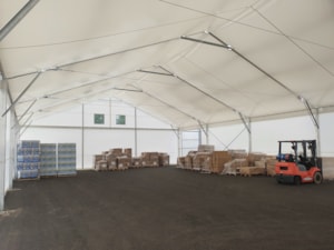 Insulated fabric storage hall with palletized goods and a forklift