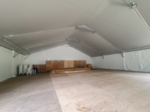 Insulated fabric hall with open storage space and stored material