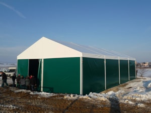 Agricultural tent hall on a snowy site for storing materials and equipment