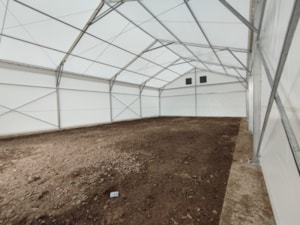 Fabric agricultural hall with a spacious interior and an unpaved floor