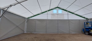 Fabric agricultural hall with a front wall and windows in the gable