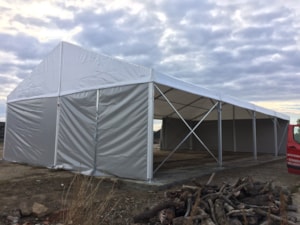 Fabric agricultural hall with an open side for covered storage