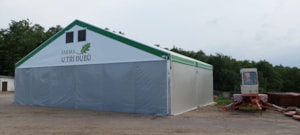 Fabric agricultural hall with side cladding in an operational yard