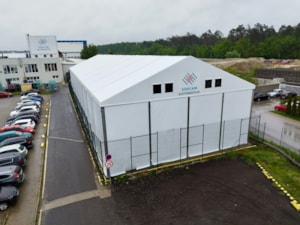 Stanová hala u firemního parkoviště – bílá hala se štítem a okny