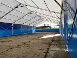 Interiér haly s modrými boky – sedlová střecha, průmyslová podlaha