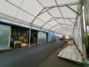 Zastřešený koridor u budovy – stanová hala jako krytý průjezd/expedice