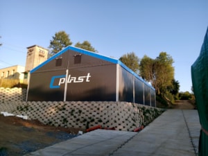 Stanová hala s tmavým opláštěním a modrým lemem – firemní potisk