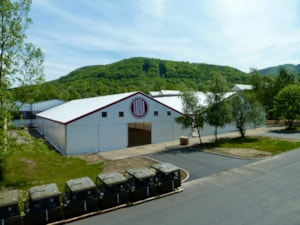 Stanová hala u přírodního svahu – čelní pohled s logem na štítu