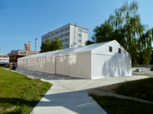 Dlouhá stanová hala na betonové ploše – boční pohled v areálu