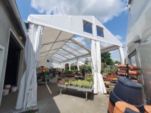 Eingang zur Planen-Zelthalle für Blumenverkauf – offene Front und Verkaufstische